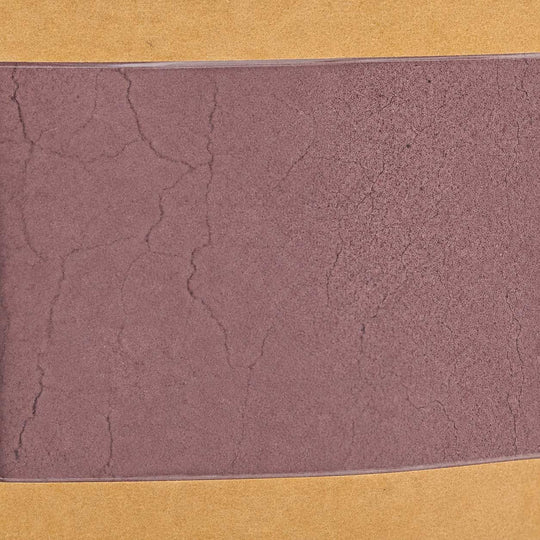 Textured purple color swatch on a yellow background