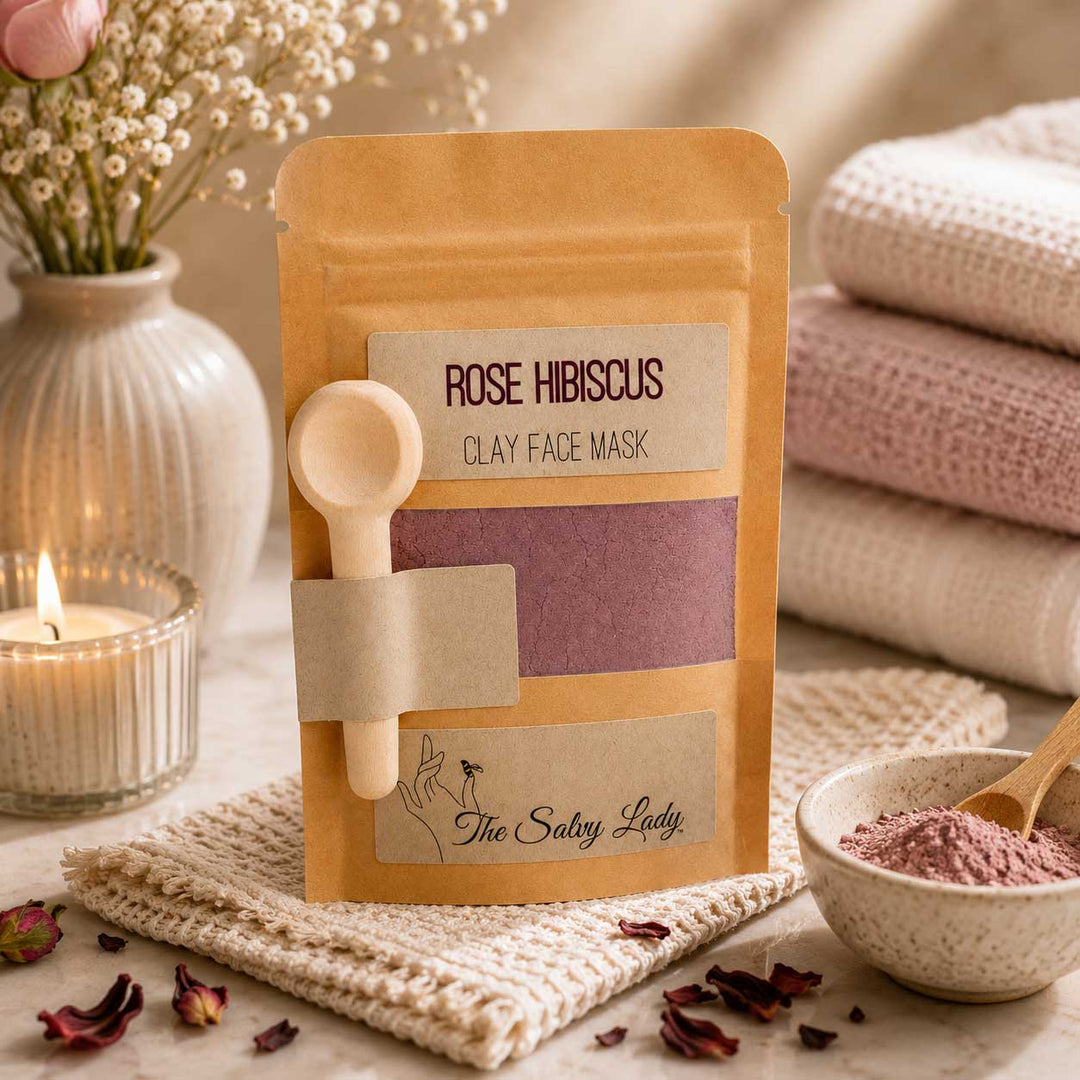 Rose Hibiscus Clay Face Mask packaging with a spoon on a neutral background