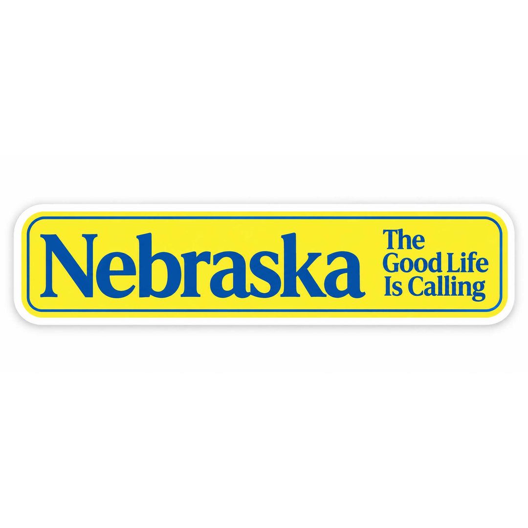 A rectangular bumper sticker with a bright yellow background, blue border, and blue text reading 'Nebraska' with the phrase 'The Good Life Is Calling' on the right, shown on a plain white background.
