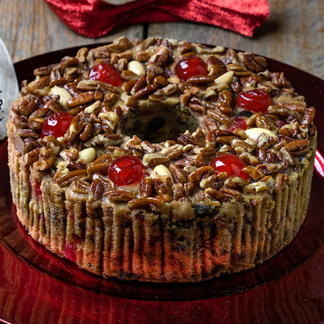 Festive fruit cake with nuts and cherries on a red plate