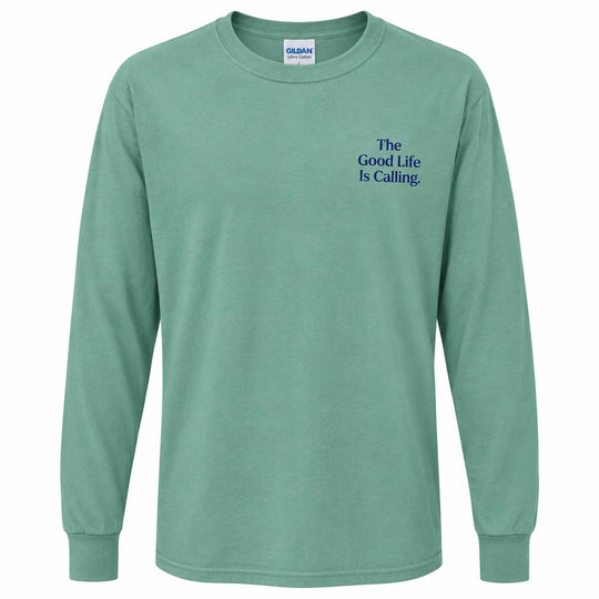 A mint green long-sleeve t-shirt with 'The Good Life Is Calling.' printed in blue text on the left chest, displayed on a clean white background.