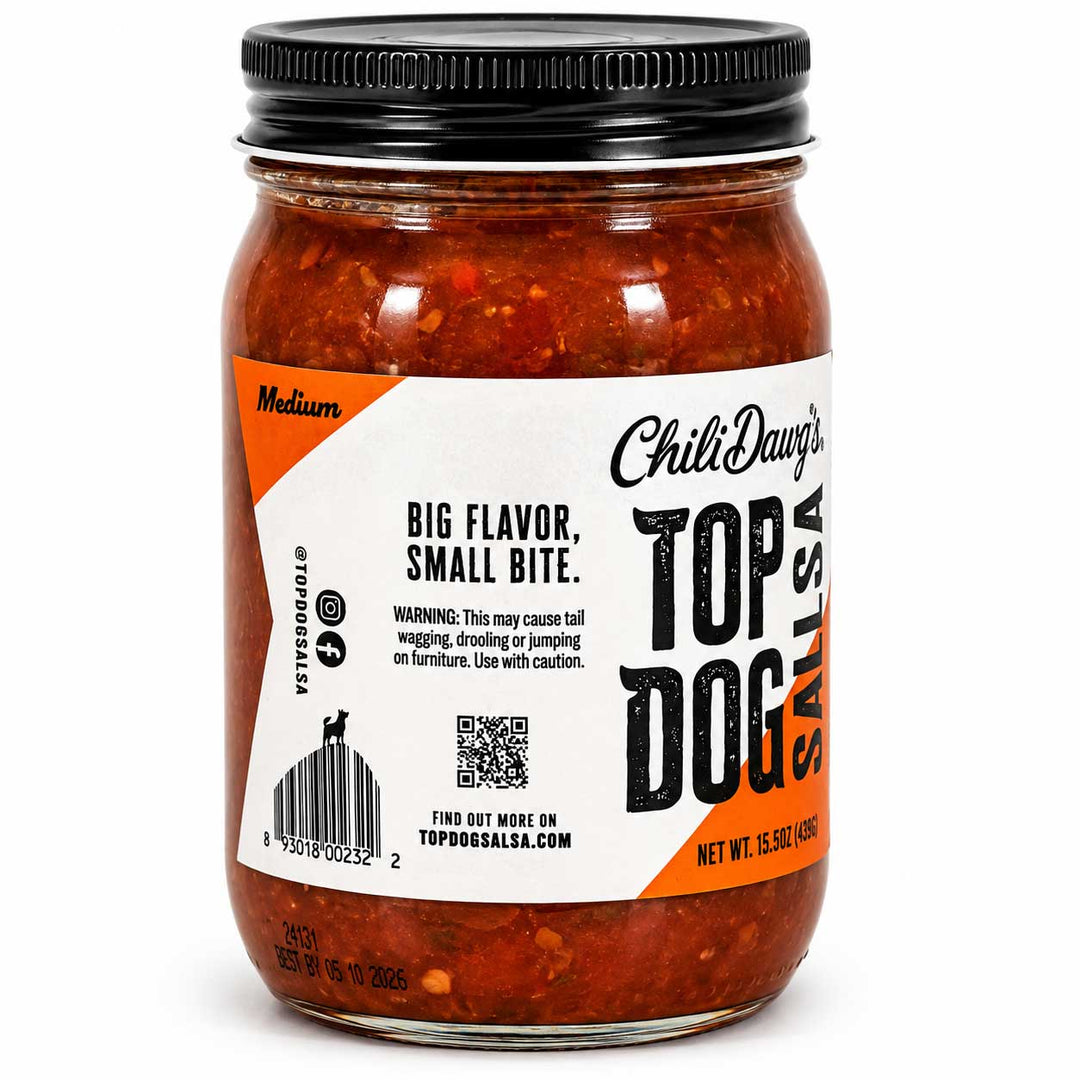 A glass jar of Chili Dawg's Top Dog Salsa with a black metal lid, filled with a medium red-orange salsa. The white and orange label features the brand name and product details, set against a plain white background.