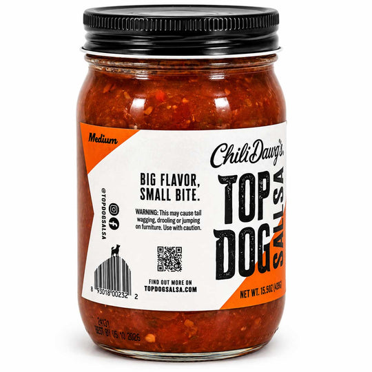 A glass jar of Chili Dawg's Top Dog Salsa with a black metal lid, filled with a medium red-orange salsa. The white and orange label features the brand name and product details, set against a plain white background.