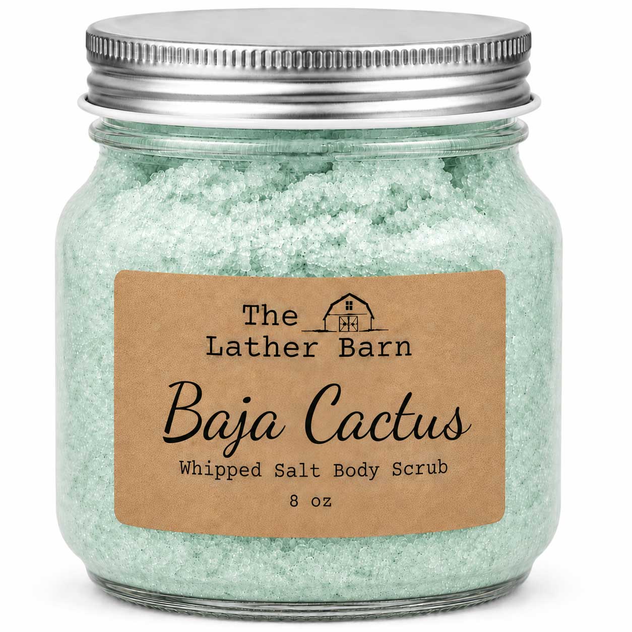 A glass jar of The Lather Barn Baja Cactus Whipped Salt Body Scrub, filled with pale mint green scrub and topped with a silver metal lid, set against a plain white background.