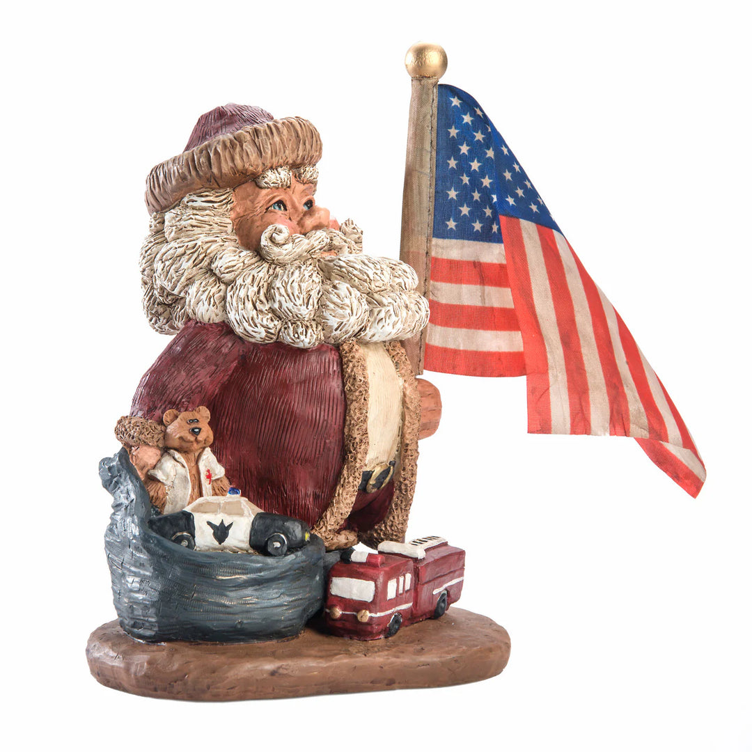 Figurine of Santa with an American flag and small vehicles on a white background