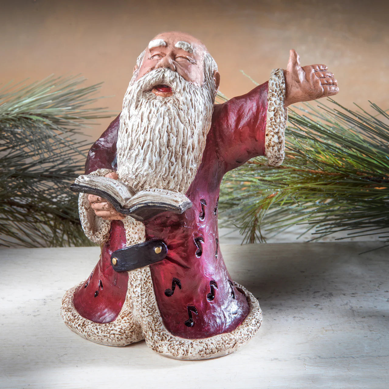 Decorative figurine of a bearded man in red robes with a book, against a neutral background.