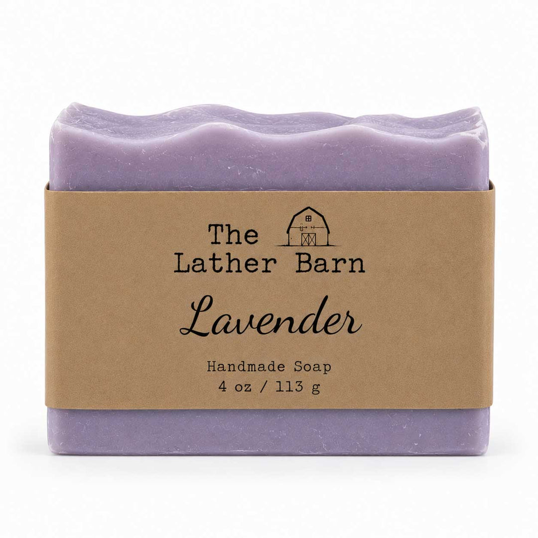 A single bar of lavender handmade soap wrapped in a kraft paper band labeled 'The Lather Barn Lavender', shown on a clean white background.
