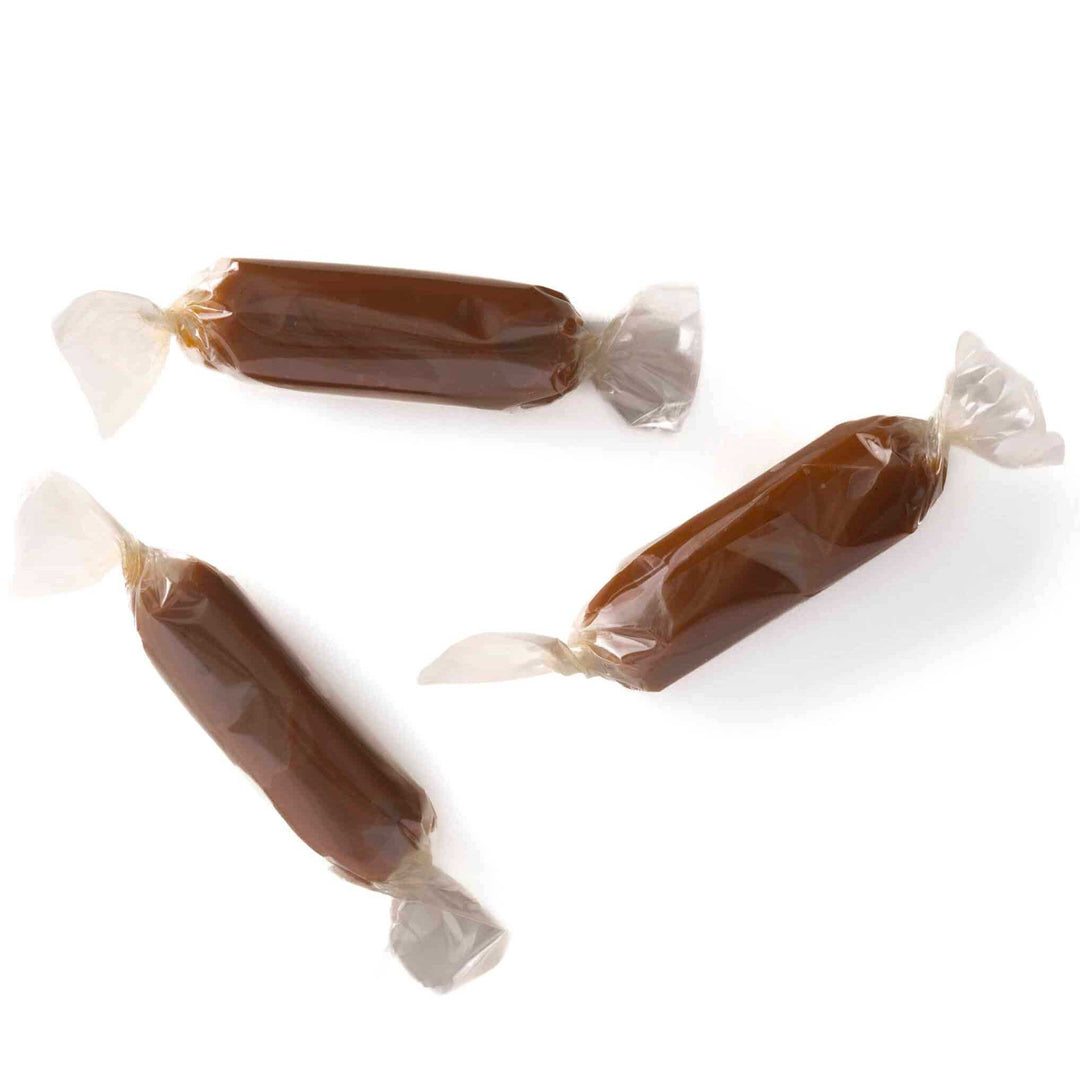 Three wrapped caramels on a white background