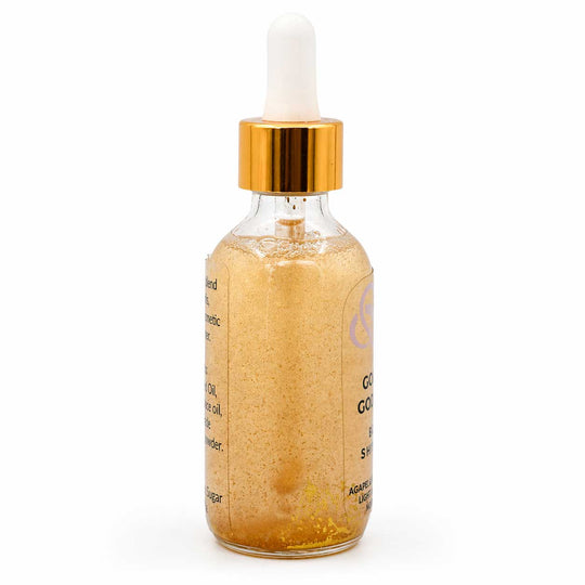 Glass dropper bottle with gold cap and gold liquid on a white background