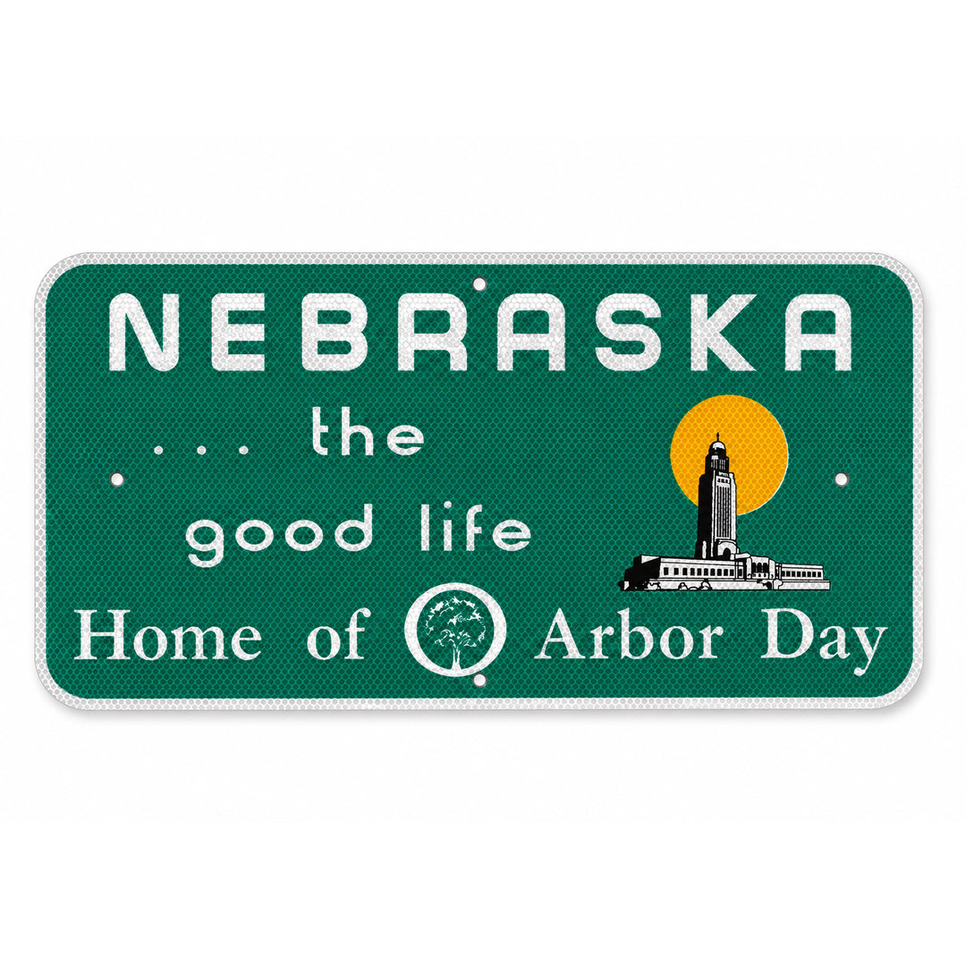 A rectangular Nebraska-themed decorative sign with rounded corners, featuring a dark green textured background, white text reading 'NEBRASKA .