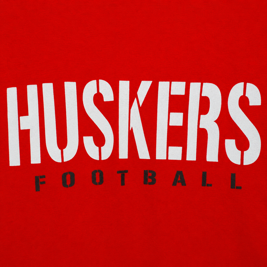 Red shirt with 'HUSKERS FOOTBALL' text in white and black