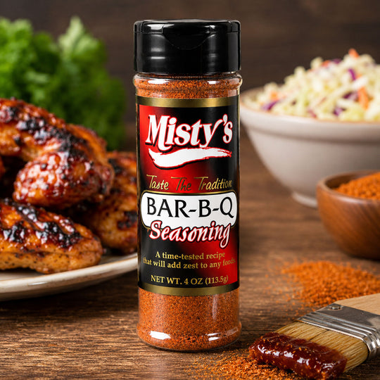 Bottle of Misty's Bar-B-Q Seasoning with grilled chicken and coleslaw in the background.