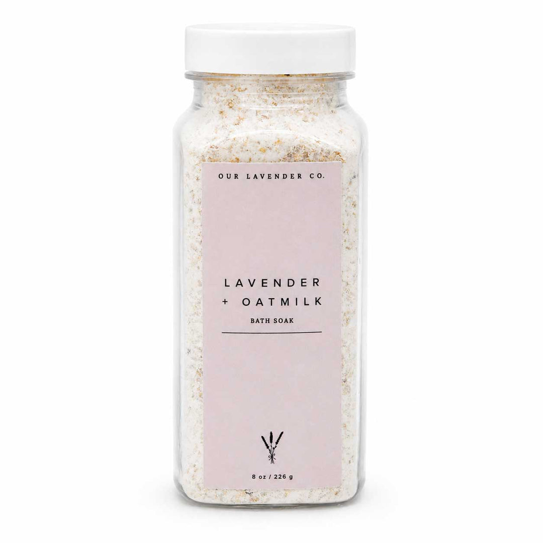Bottle of lavender oatmilk bath soak with a white lid on a white background