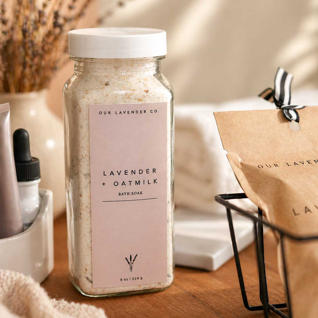 Jar of lavender and oatmilk bath soak with a branded label on a wooden surface.