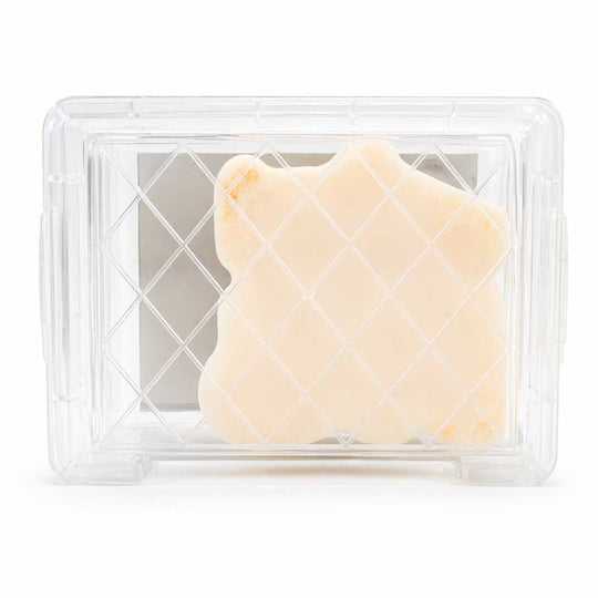 Two pieces of butter in a clear plastic container on a white background