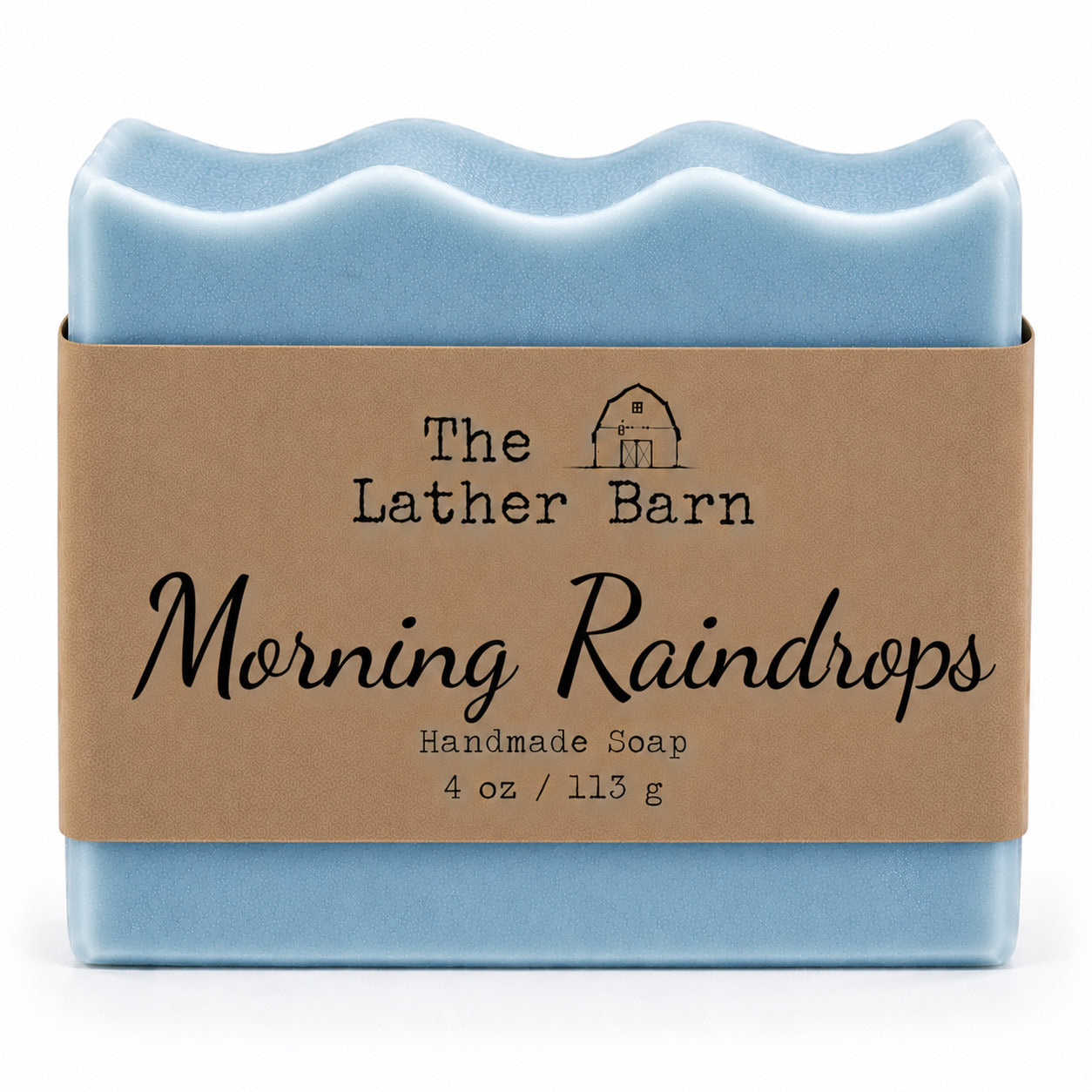 A bar of handmade soap wrapped in a brown kraft paper band. The soap has a wavy top edge and is a light sky blue color.