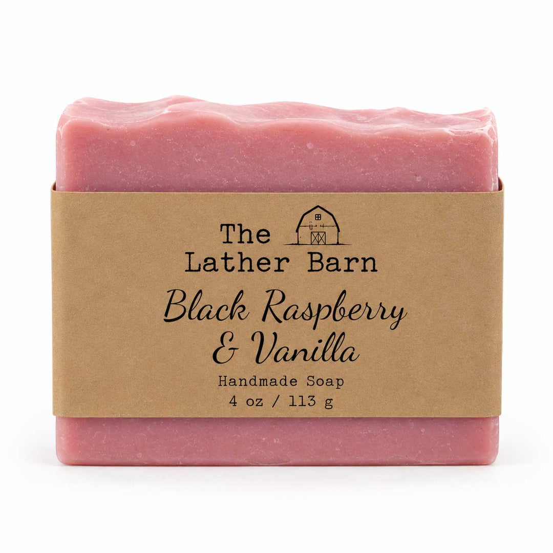 A single bar of handmade soap in pink packaging with a kraft paper label reading 'The Lather Barn Black Raspberry & Vanilla Handmade Soap 4 oz / 113 g' on a white background.