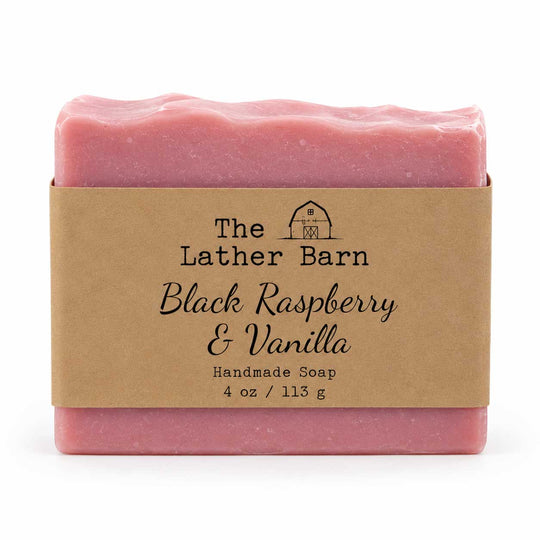 A single bar of handmade soap in pink packaging with a kraft paper label reading 'The Lather Barn Black Raspberry & Vanilla Handmade Soap 4 oz / 113 g' on a white background.