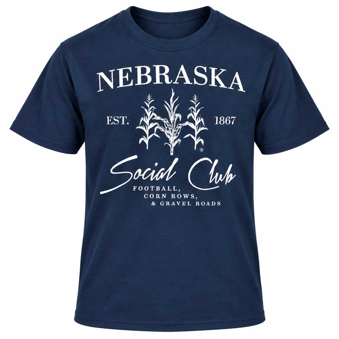 A navy blue short-sleeve t-shirt with a white graphic print on the front. The graphic features the word 'NEBRASKA' in arched capital letters above three white corn illustrations, with 'EST.