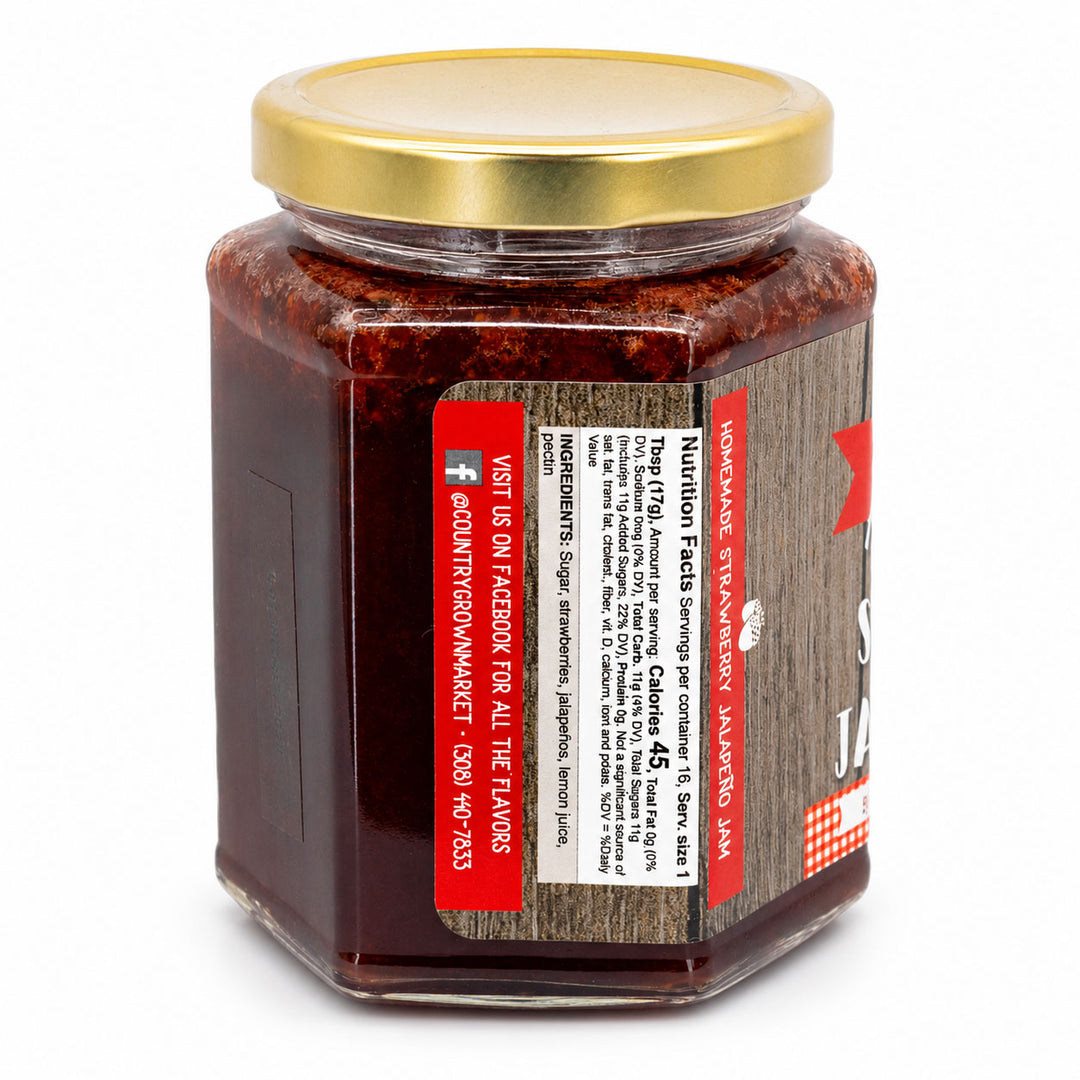 Jar of strawberry jam with a gold lid on a white background