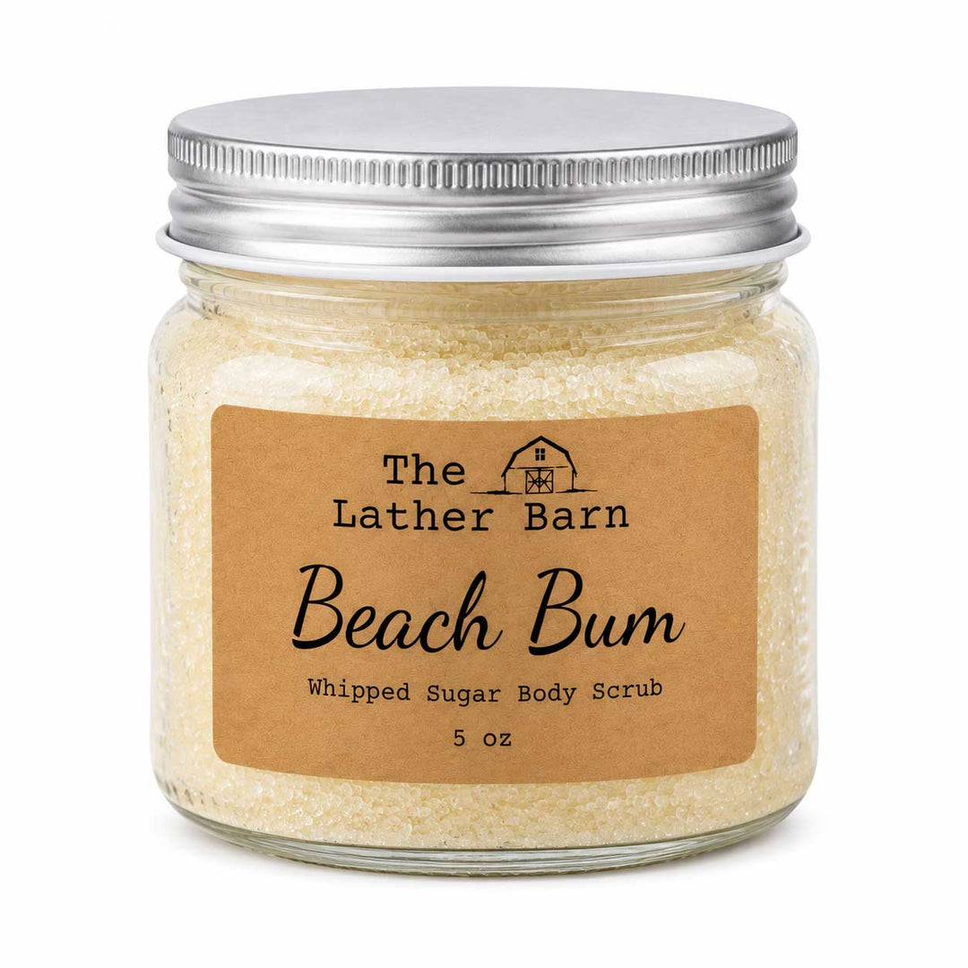 A 5 oz glass jar of The Lather Barn Beach Bum Whipped Sugar Body Scrub, filled with pale beige scrub and sealed with a silver metal lid, set against a plain white background.