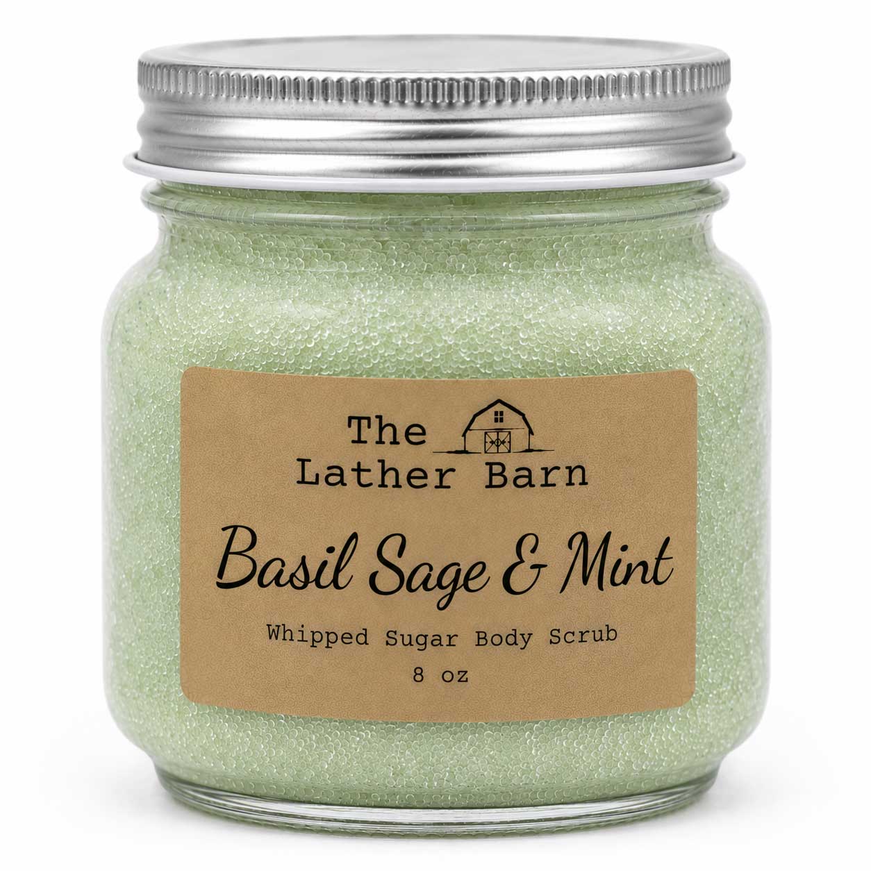 A glass jar of The Lather Barn Basil Sage & Mint Whipped Sugar Body Scrub, filled with light green glittery scrub and topped with a silver metal lid, set against a plain white background.