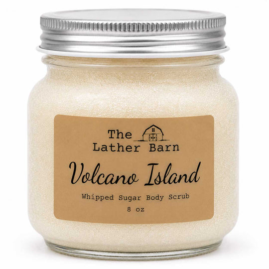 An 8 oz jar of whipped sugar body scrub by The Lather Barn, featuring a beige kraft paper label and a silver metal screw cap, shown on a white background.