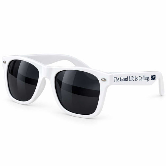 White sunglasses with dark lenses and the text 'The Good Life Is Calling.' printed on the temple arm, shown on a clean white background.