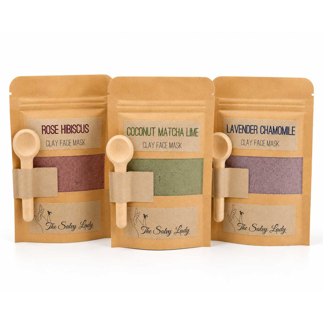 Three packages of 'The Salty Lady' clay face masks with wooden spoons on a white background