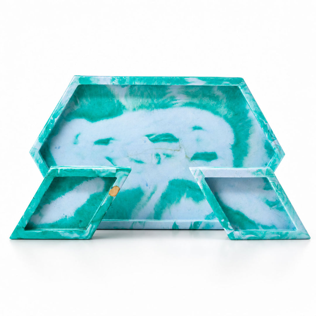 Set of three green and white marbled trays on a white background