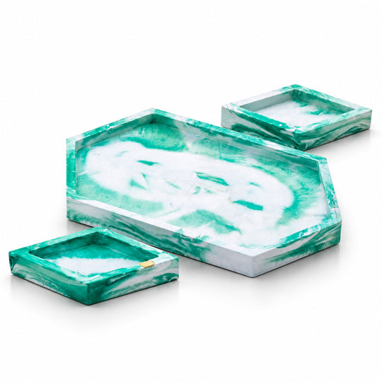 Set of three green and white marbled trays on a white background