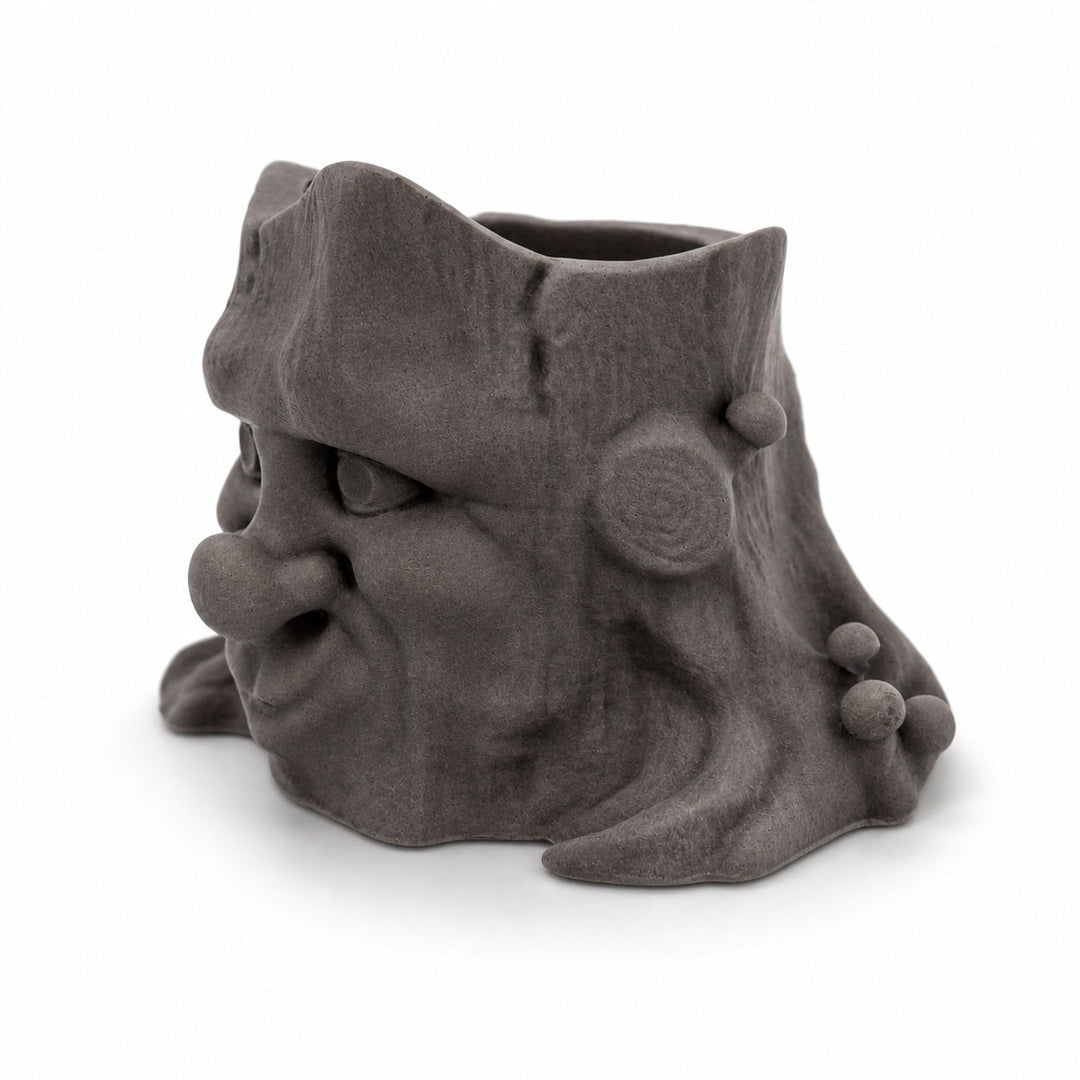 Gray ceramic face-shaped planter on a white background