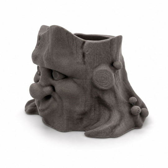 Gray ceramic face-shaped planter on a white background