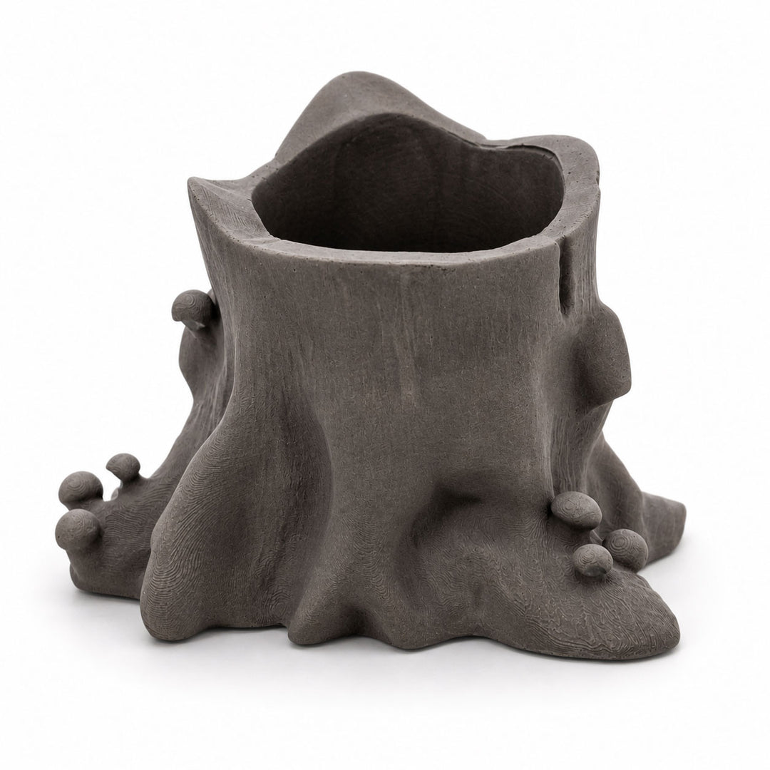 Ceramic planter shaped like a tree stump with bulbous ends on a white background