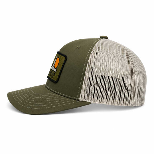 An olive green and beige trucker hat with a curved brim, featuring a front patch logo and a beige mesh back.