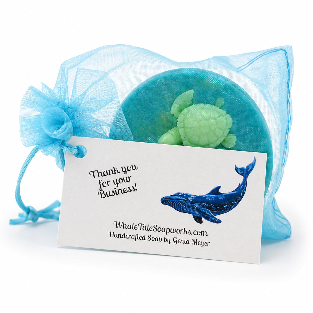 Soap with turtle design in a blue drawstring bag with Whale Tale Soapworks branding.