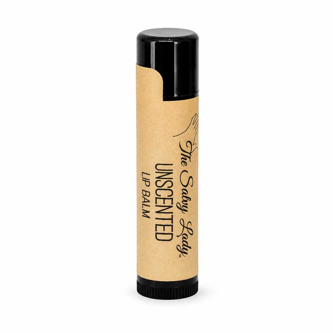 Lip balm with black lid and beige cream on a white background