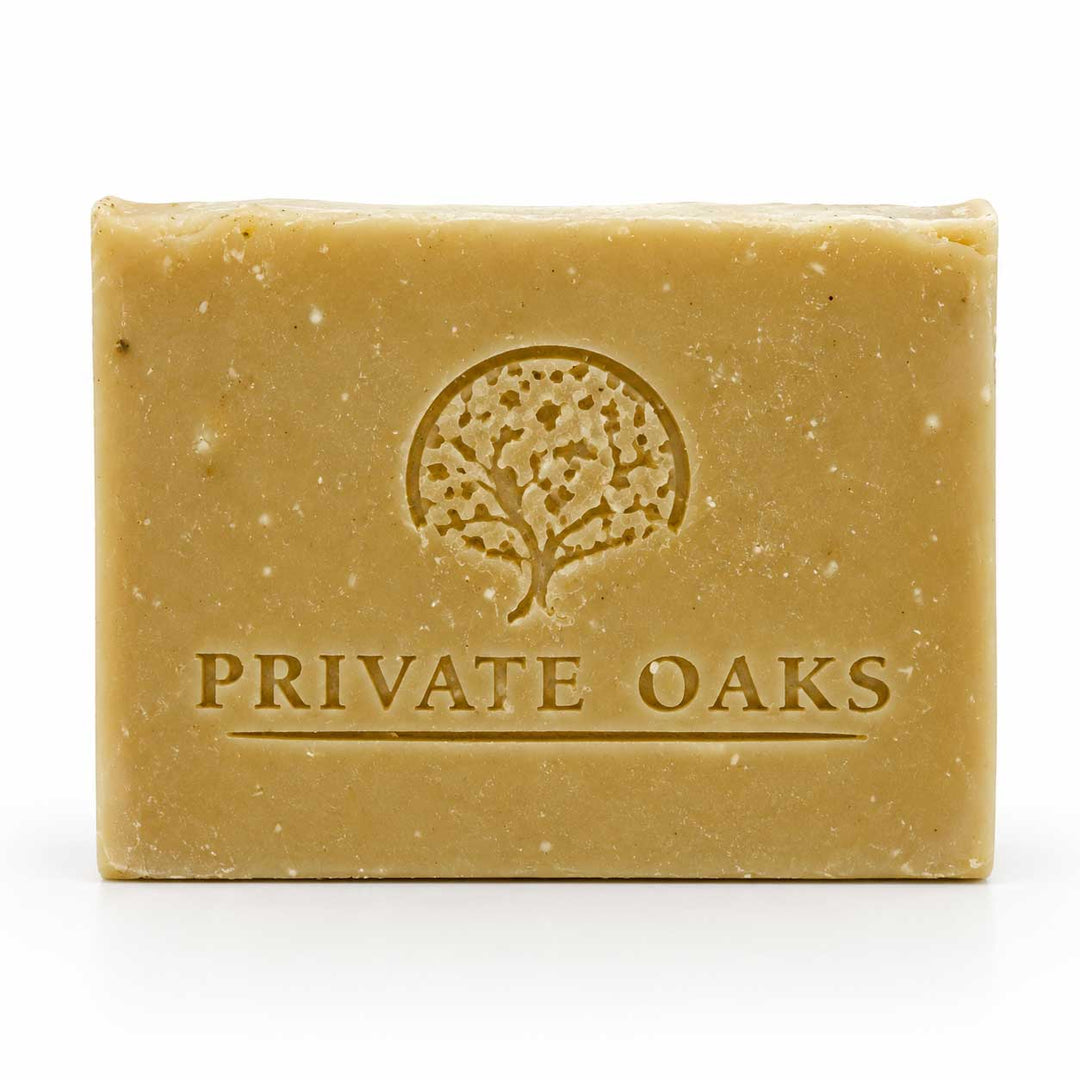A rectangular bar of natural soap in a warm tan color, embossed with a tree logo and the brand name 'PRIVATE OAKS' on the front, set against a plain white background.