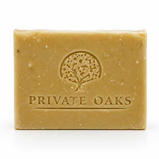 A rectangular bar of natural soap in a warm tan color, embossed with a tree logo and the brand name 'PRIVATE OAKS' on the front, set against a plain white background.
