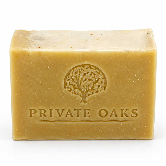 A rectangular bar of natural soap in a warm tan color, embossed with a tree logo and the brand name 'PRIVATE OAKS' on the front, set against a plain white background.