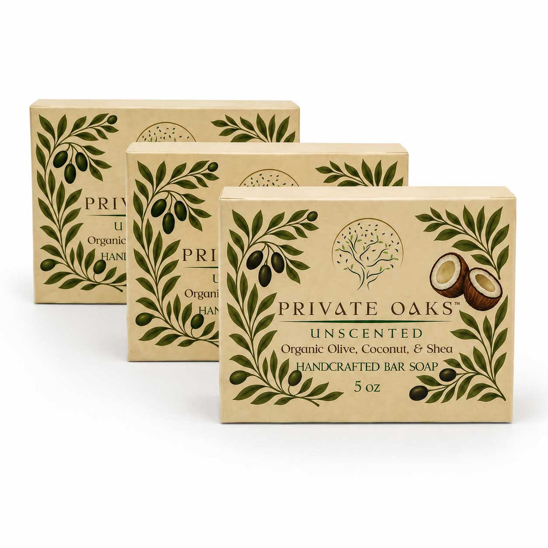 Three boxes of Private Oaks Unscented Handcrafted Bar Soap arranged in a staggered row on a white background. The beige packaging features green olive branch illustrations and text highlighting organic olive, coconut, and shea ingredients.