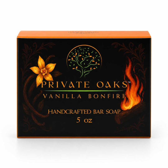 A 5 oz box of Private Oaks Vanilla Bonfire handcrafted bar soap. The packaging is black with gold lettering, an orange top, and decorative gold and orange illustrations of a flower, a tree, and a flame.