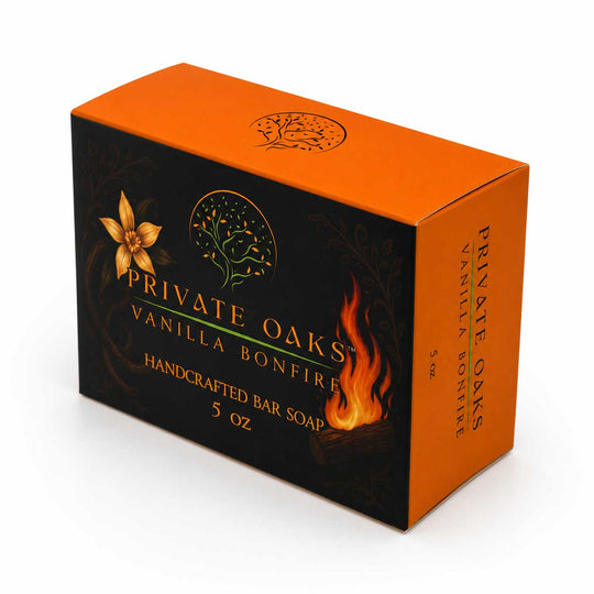 Private Oaks Vanilla Bonfire handcrafted bar soap box, 5 oz. The packaging features a black front and side panels with gold lettering, a gold oak leaf logo, and orange flames, while the top and back are bright orange.
