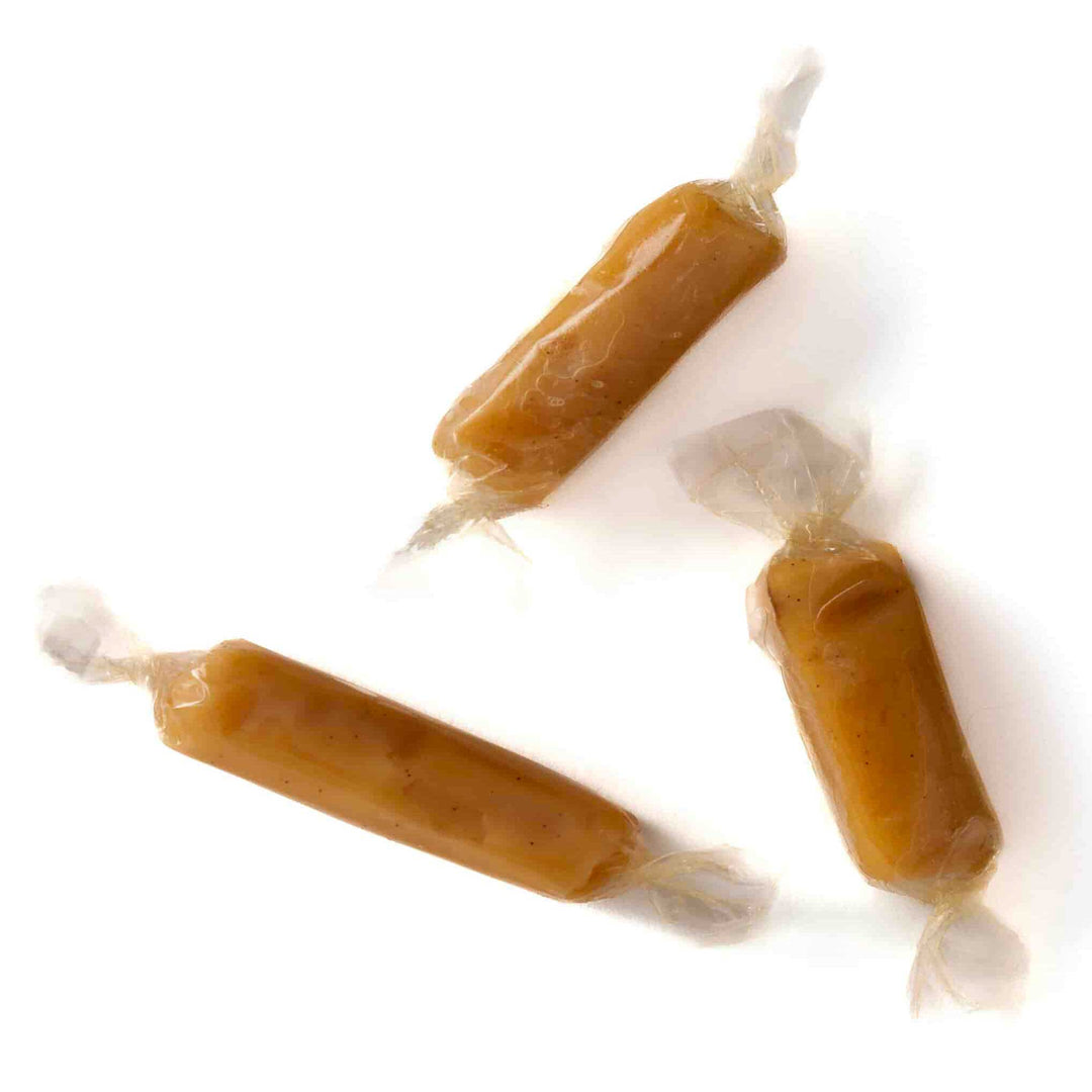 Three wrapped caramels on a white background