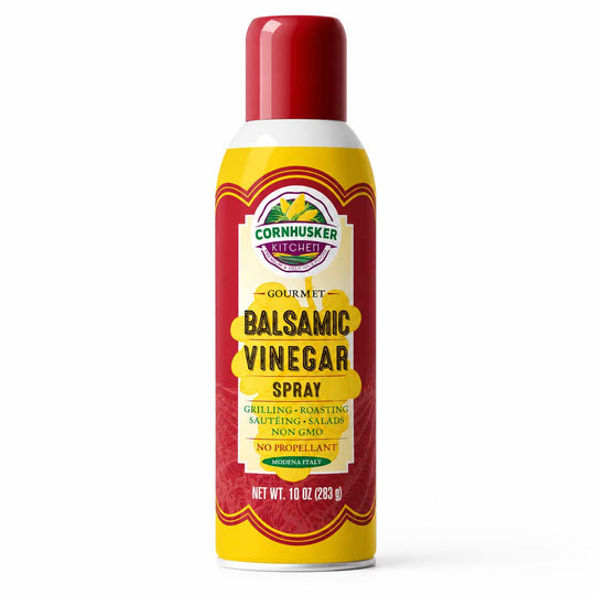 A 10 oz can of Cornhusker Kitchen Gourmet Balsamic Vinegar Spray, featuring a red cap, yellow and red label, and white base on a clean white background.