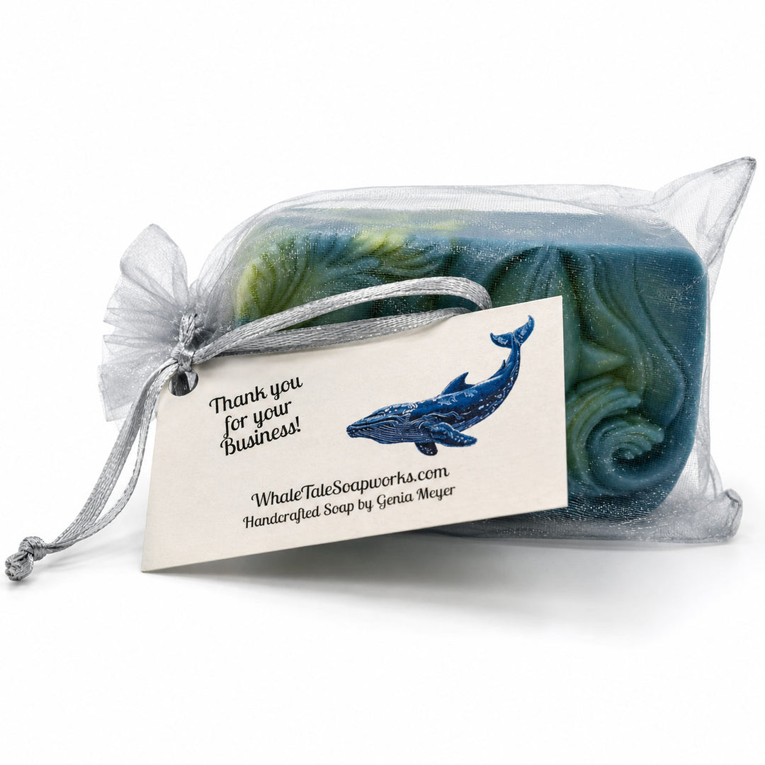 Packaged soap with a whale design and business card on a white background