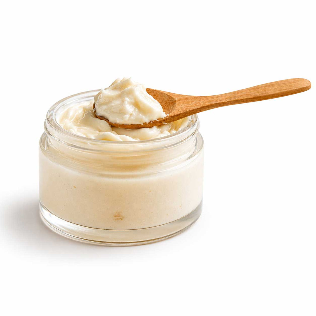 Jar of cream with a wooden spoon on a white background