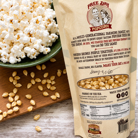 Free Day Popcorn bag with popcorn and kernels on a wooden surface
