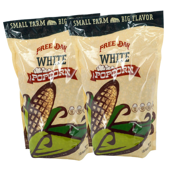 Two packages of Free Day White Popcorn with corn illustrations on a white background