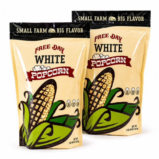 Two packages of Free Day White Popcorn with corn illustrations on a white background